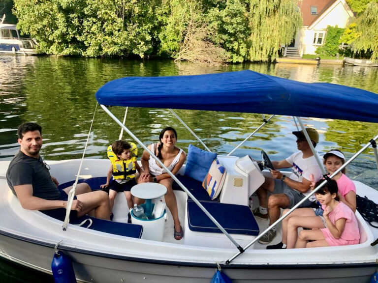 Family cruising on Uncle Johnny Ruban Bleu Scoop - electric launch, 7-seater grey hull with blue cushions